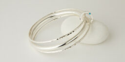 Three Recycled Silver Bangles Connected with Flush Set Silver Disc