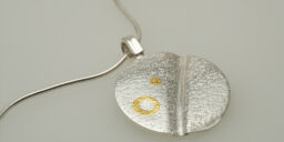 Silver textured pendant decorated with ethical gold