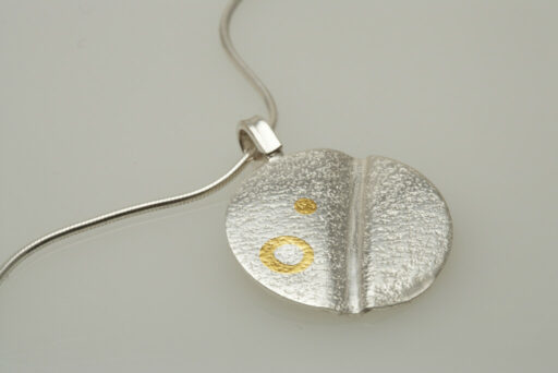Silver textured pendant decorated with ethical gold